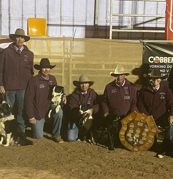 Queensland team with cattle dogs and trophy posing in arena